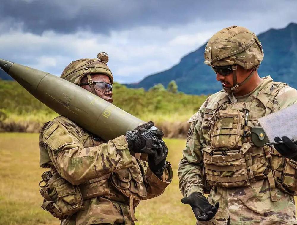 Soldiers handling an artillery round